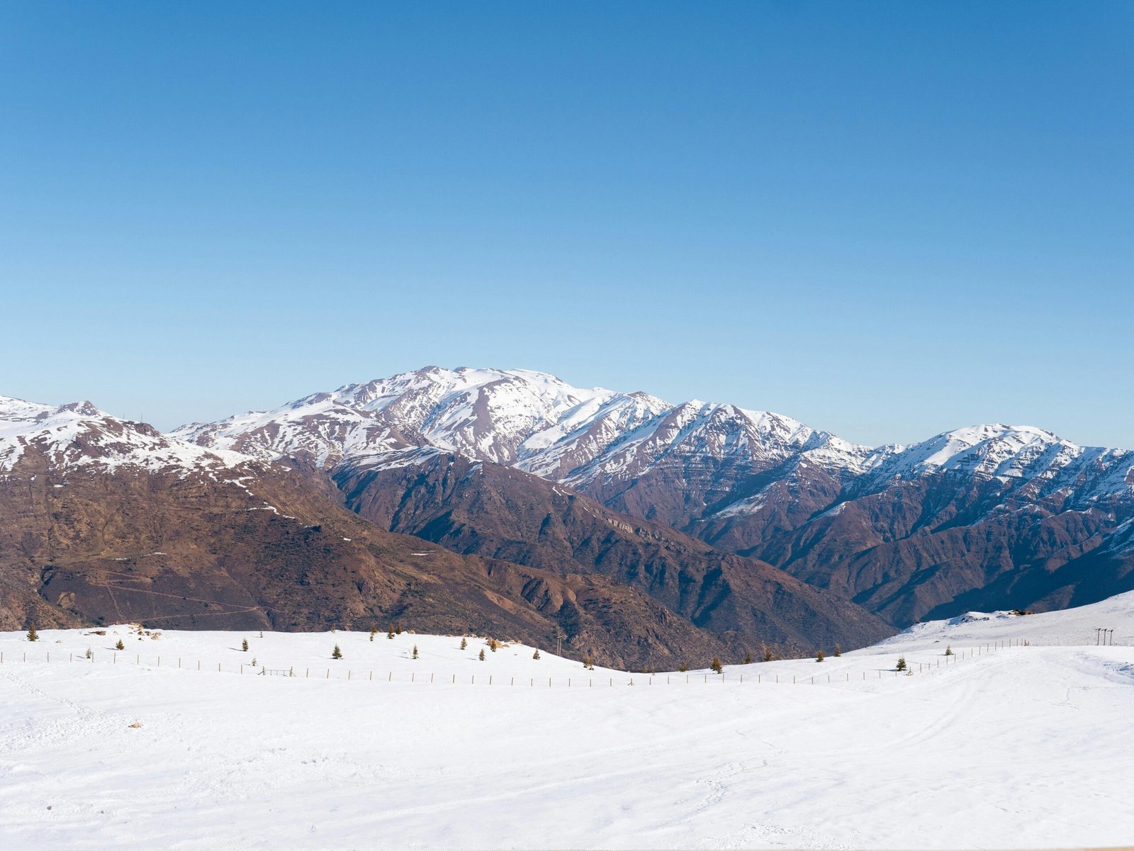 Clear view of snowy Andean mountains against blue sky, ideal for winter travel themes.