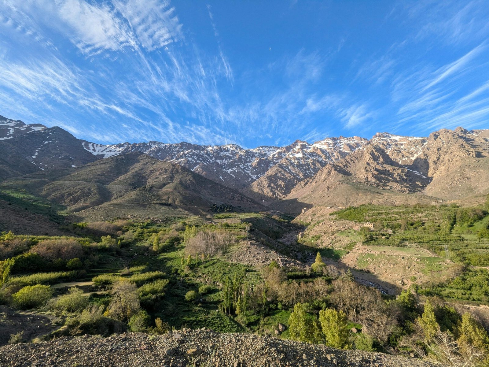 A breathtaking view of the Atlas Mountains in Tachdirt, Souss-Massa, showcasing lush green valleys and striking peaks.