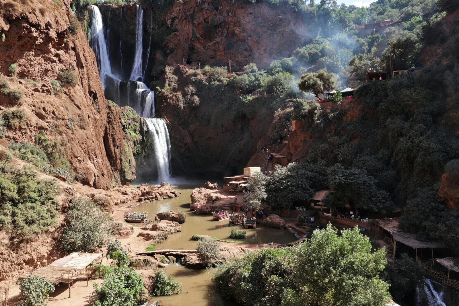 Stunning waterfall cascading through rocky cliffs surrounded by vibrant greenery in a tranquil canyon.
