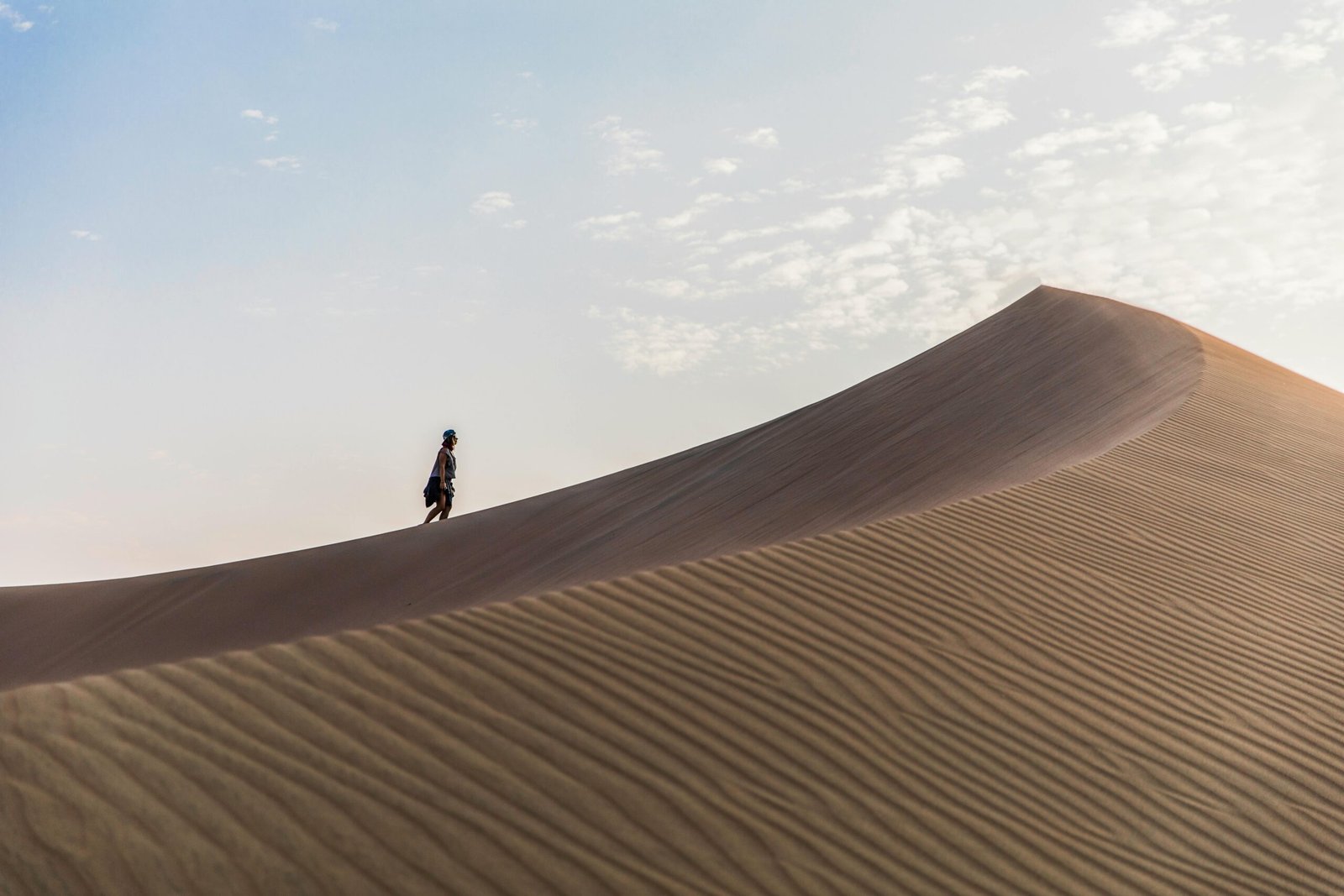 A lone traveler explores the majestic sand dunes of Huacachina, Peru.