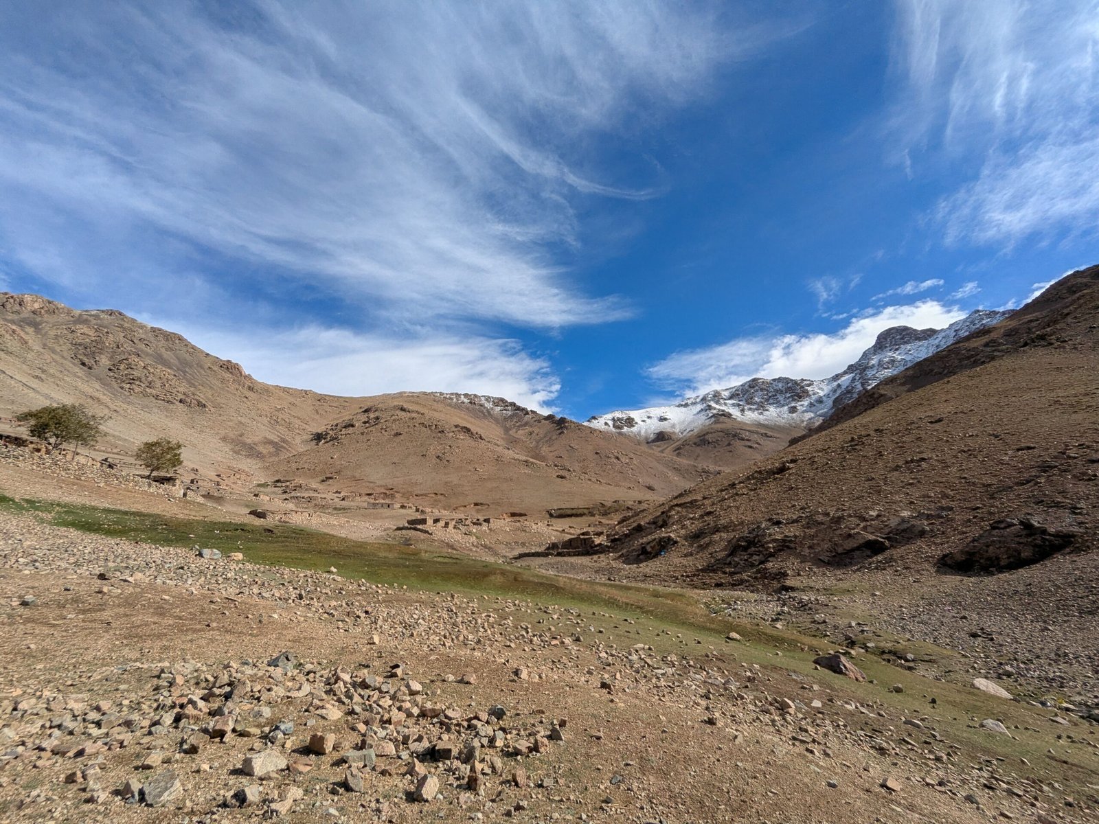 Stunning view of a rocky mountain landscape with clear blue sky and clouds.